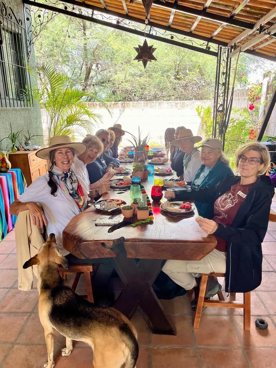 The circle sharing lunch at the long table at Rancho Baile de la Luna